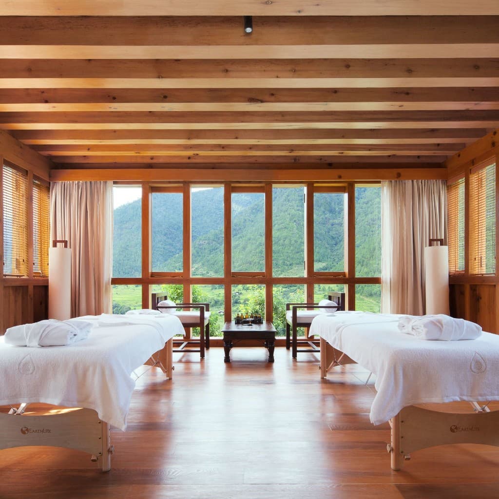 COMO Uma Punakha spa treatment room with massage tables and mountain views